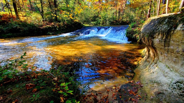 A scene of Trout Falls on the La Crosse River in the Pine View Recreation Area is shown with fall colors Sept. 30, 2021, at Fort McCoy, Wis. The recreation area includes acres of publicly accessible land with hiking trails, Pine View Campground, Whitetail Ridge Ski Area, and Sportsman’s Range. Pine View Recreation Area offers four-season, year-round activities to include camping, hiking, fishing, and more. See more about the area at https://mccoy.armymwr.com/categories/outdoor-recreation. (U.S. Army Photo by Scott T. Sturkol, Public Affairs Office, Fort McCoy, Wis.)