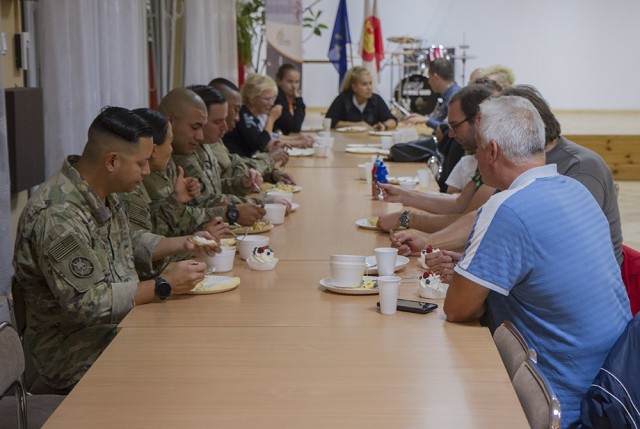 U.S. Army Soldiers assigned to the Florida Guard’s 50th Regional Support Group, enjoy a meal with locals after preparing the food with members of a local women’s organization at the Powidz Community Center in Powidz, Poland, Oct. 5, 2021. They...