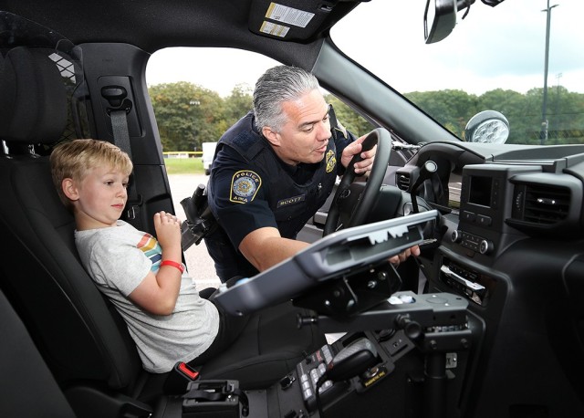 Ken Scott from the U.S. Mint Police shows 7-year-old Beau Bentley various items in his police car, to include how to work the siren.