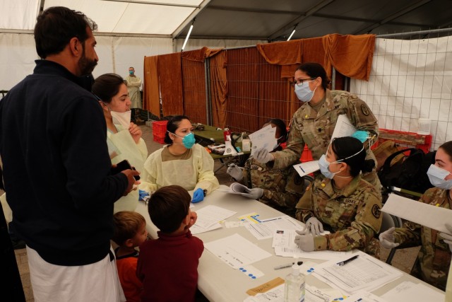 Medical personnel check in Afghan evacuees waiting to receive measles, mumps and rubella and chickenpox vaccines. A diverse team of Army medical professionals vaccinated nearly 5,500 Afghan evacuees in less than 72 hours at Rhine Ordnance...