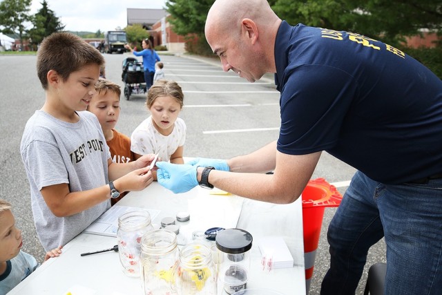 10-year-old Tommy Korpela learns how to dust for fingerprints from West Point Criminal Investigation Division Special Agent Paul Mummey.