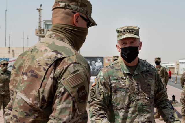 General Stephen R. Lyons, U.S. Transportation Command commander, congratulates Captain Brian Hansen, 386th Air Expeditionary Wing, chief of protocol, March 23, 2021 at Ali Al Salem Air Base, Kuwait.  Hansen was one of eight members of the 386th Air Expeditionary Wing coined by Lyons and recognized as an outstanding Airman. (U.S. Air Force photos by Senior Airman Taryn Butler)