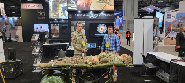 The U.S. Army Medical Center of Excellence, or MEDCoE, provided a participatory experience for attendees during the Association of the United States Army’s, or AUSA’s, Annual Meeting, October 11-13. Hundreds of Army senior leaders, industry leaders and other interested AUSA participants stopped by the MEDCoE kiosk for a fully interactive demonstration that highlighted the Tactical Combat Casualty Care Exportable, or TC3X, mannequin, offering an opportunity to see the simulation capabilities in action during live, hands-on exhibitions. Pictured: MEDCoE’s kiosk leads, Master Sgt. Kaleb Twilligear and James Kinser pose at the AUSA display on October 11, 2021.