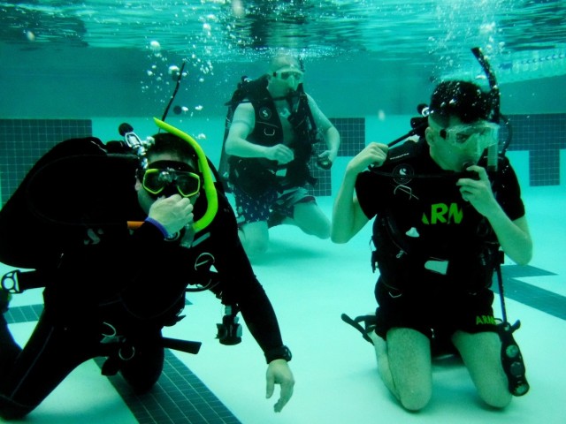 Juan Carrasco (left), Master Sgt. Neil Ashley (center), and Spc. Joseph Suarez (right) posed for a photo during an Intro to Scuba class offered by the Fort Drum Soldier Recovery Unit, New York, at the Magrath Gym on July 15. (Photo courtesy of...