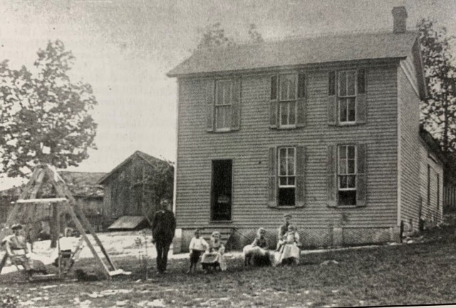 The Rahm family home as it stood in 1903. Agnes Rahm, born in 1901, is seen on her mother’s lap at the right. Agnes was the grandmother of Tim Taylor who visited the cemetery following its rediscovery in January on Oct. 11, 2021.