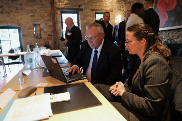 Capt. Katie McDougall, 21st Theater Sustainment Command Host Nation Support, confers with a participant at the National Territorial Commanders Committee meeting in Deidesheim, Germany October 4-6, 2021. Nearly 40 host nation support professionals...