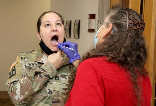 Cynthia Baker, right, a registered nurse at Madigan Army Medical Center supporting the Uniformed Services University&#39;s Infectious Disease Clinical Research Program, swabs the inside cheek of Sgt. 1st Class Patience Waycaster, the Regional Health Command-Pacific Sexual Harassment/Assault Response and Prevention program manager, as part of the flu vaccine study. Soldiers and civilian employees receiving flu vaccinations are part of a four-year study to compare the effectiveness of three existing vaccines in preventing influenza infection.