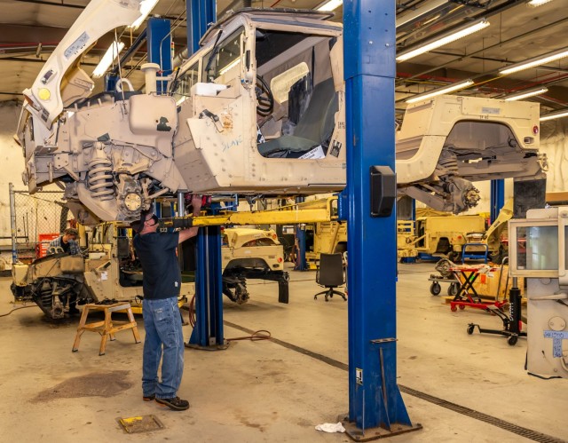 Equipment Mechanic Canio Lopomo installs a transmission on a High Mobility Multipurpose Wheeled Vehicle (Humvee). The Humvee is a family of light, four-wheel drive, military trucks and utility vehicles.