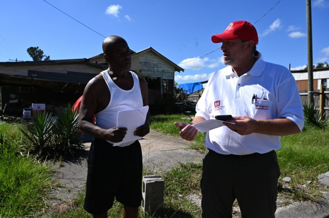 Dereck Wansing, right, a U.S. Army Corps of Engineers, Kansas City District engineering technician and local government liaison supporting Hurricane Ida recovery efforts in Louisiana, discusses the Operation Blue Roof process to a homeowner in Houma, Louisiana, Oct. 12.