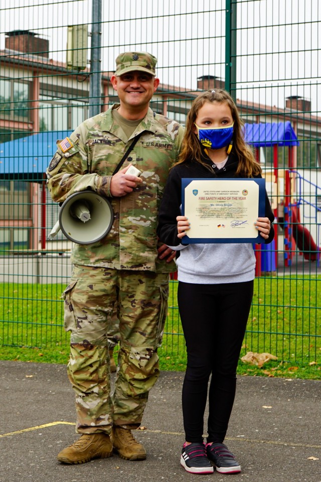 Lt. Col. Jon Jackson, provost marshal of the directorate of emergency services  recognizes 5th grader Olivia Briggs at Aukamm Elementary after an afternoon fire drill, Oct. 18, 2021, for her quick call to emergency services, preventing further fire danger at a nearby residence.