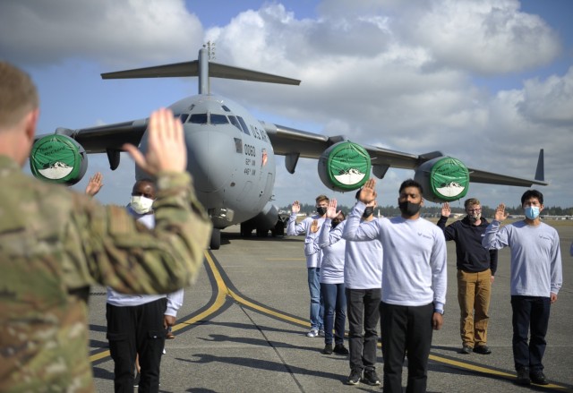 Col. Paul Skipworth, commander of the 446th Airlift Wing, administers the Oath of Enlistment to 20 recruits during a mass enlistment ceremony on Oct. 1, 2021 at Joint Base Lewis-McChord, Washington. The ceremony was organized by the Air Force...