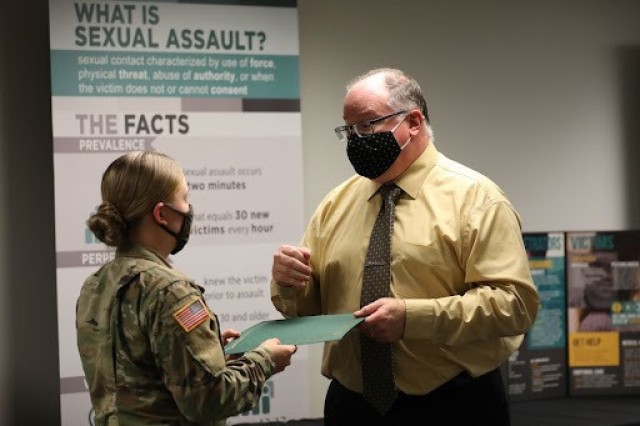 Robert Lewis, the 3rd Infantry Division Sexual Harassment Assault Response Prevention Program Manager, presents Spc. Gracelynn Miller, assigned to 2nd Armored Brigade Combat Team, 2nd Battalion, 69th Armor Regiment, 3rd Infantry Division, with a Certificate of Achievement following her completion of the Marne Guardian course on Fort Stewart, Georgia, Oct. 15, 2021.  Marne Guardian focuses on empowerment and trains junior Soldiers on the policies and resources necessary to inform their peers, support the command in training, or potentially intervene with matters pertaining to the SHARP program, equal opportunity, resiliency and suicide prevention.  (U.S. Army photo by Pfc. Elsi Delgado)