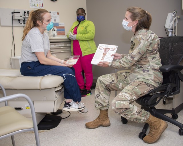 Army Maj. (Dr.) Kayla Jaeger, Adolescent and Young Adult Medicine chief, discusses contraception options with patient, Air Force Capt. Jacqueline Wade, while Benesha Jackson, licensed vocational nurse, gathers instruments for an exam at the CPT Jennifer M. Moreno Primary Care Clinic, Fort Sam Houston, Texas, Oct. 20, 2021. The Patients in Need of Contraception (PINC) clinic, which offers female service members a walk-in clinic for contraception on Wednesdays from noon to 2 p.m., is open to all female permanent party active duty service members assigned to Joint Base San Antonio.  (U.S. Army photo by Jason W. Edwards)