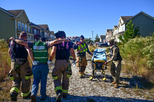 Fort Jackson, South Carolina, firefighters help a mock injured civilian worker walk to an awaiting ambulance after a fictional tornado struck his crew in on-post housing Oct. 19, 2021. The role players were a part of an annual, post-wide...
