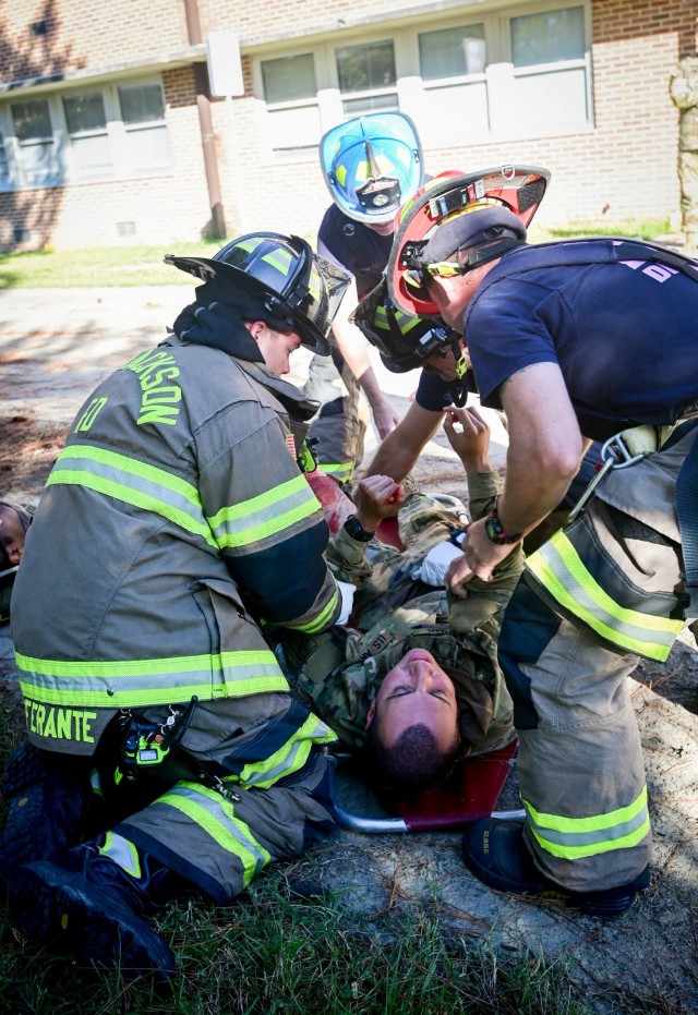 Fort Jackson, South Carolina, firefighters move a mock injured trainees onto a spine board in preparation of moving him to a secure area on Oct. 19, 2021. The injured trainee role played an amputee during an annual Full-scale Training Exercise....