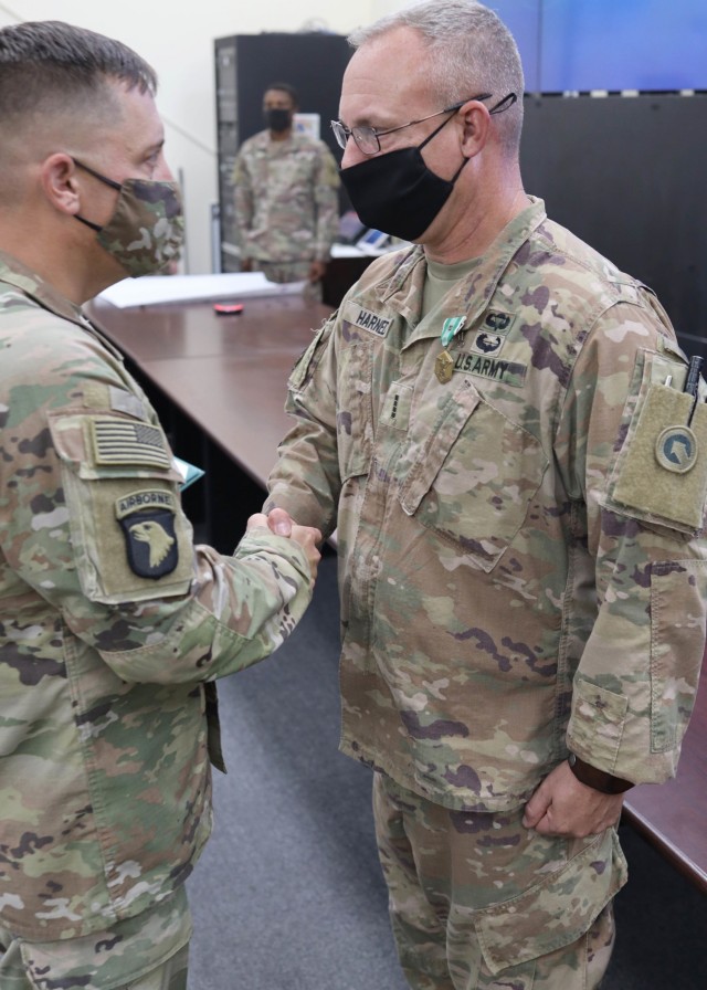 1st Theater Sustainment Command Deputy Commanding Officer Sean P. Davis congratulates Chief Warrant Officer 4 Scott O. Harned, 1st TSC (Forward), after awarding him with the Army Commendation Medal with the "C" device for combat conditions during an Oct. 7, 2021 ceremony at 1st TSC's operational command post, Camp Arifjan, Kuwait. Davis presented the medal to Harned in recognition of his exceptionally meritorious service during his deployment to Afghanistan to support U.S. forces from July 28, 2021, to Aug. 30, 2021.
