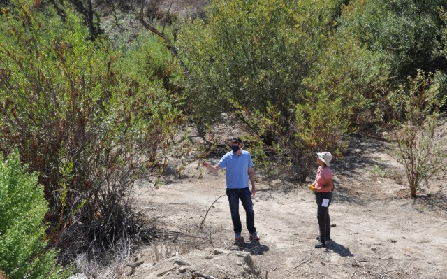 Los Angeles District team members Spencer MacNeil,(left) chief of the  Transportation and Special Projects Branch, and Jeniffer Aleman-Zometa, manager for Regulatory Project, discuss the recovery of Agua Chinon Wash after the Dec. 14 Silverado wildfire, Sept. 16, in Irvine, California. The area, an elderberry  scrubland is sandwiched between Interstate 5 and a ridgeline of steep box canyons.