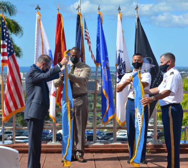 DHA Assistant Director Dr. Brian Lein and Hawaii Market Director Col. Martin 
Doperak unfurl the flags during the formal Hawaii Market Establishment Ceremony.