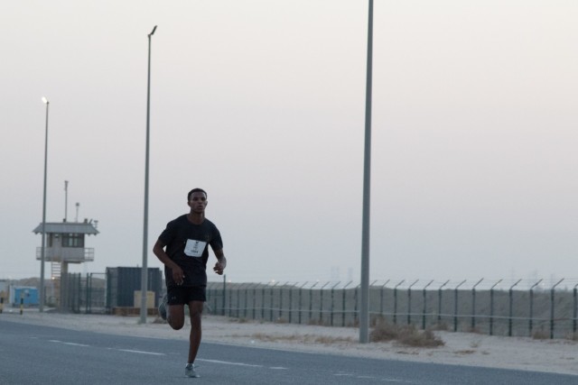 Spc. Yacob I. Warsame, a signal support systems specialist assigned to 3rd Expeditionary Sustainment Command, leads the pack at mile seven of the Army Ten-Miler Shadow Run at Camp Arifjan, Kuwait, on Oct. 10, 2021. Warsame, a native of Denver, Colo., currently deployed in support of the 1st Theater Sustainment Command Operational Command Post, ultimately placed second in the race with a time of one hour, six minutes, and 11 seconds. The signal support systems specialist said joining the Army has helped him unlock his potential.