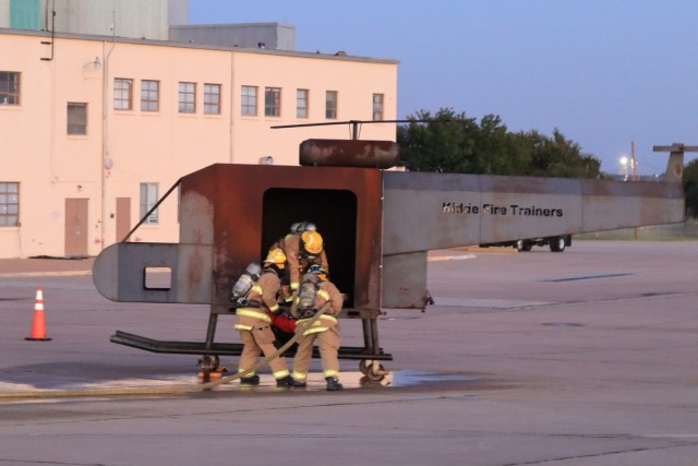 After accessing the helicopter, Fort Sill firefighters concentrate on getting the victim out and to safety during the nighttime aircrew evacuation training on Henry Post Army Air Field Oct. 20, 2021.