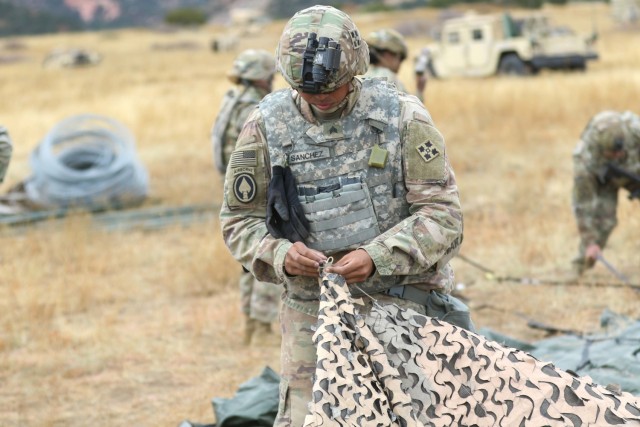 Sgt. Christopher Sanchez, a satellite communication systems operator-maintainers assigned to Charlie Company, 404th Aviation Support Battalion, 4th Combat Aviation Brigade, 4th Infantry Division ties together camouflage netting, Fort Carson, Colorado, Oct. 12, 2021. Operation Cornerstone is a field exercise designed to train personnel on sustainment operations and demonstrate the battalion's support capabilities. (U.S. Army photo by Sgt. Ashton Empty)