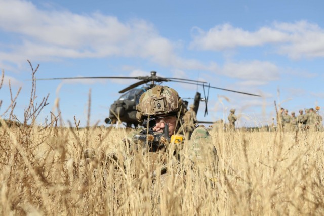 A Soldier assigned to B. Co, 404th Aviation Support Battalion, 4th Combat Aviation Brigade, 4th Infantry Division, guards an AH-64 Apache helicopter while his unit performs downed aircraft recovery teams (DART) training during Operation Cornerstone, Fort Carson, Colorado, Oct. 14, 2021. Operation Cornerstone is a field exercise designed to train personnel on sustainment operations and demonstrate the battalion's support capabilities. (U.S. Army Photo Sgt. Ashton Empty)