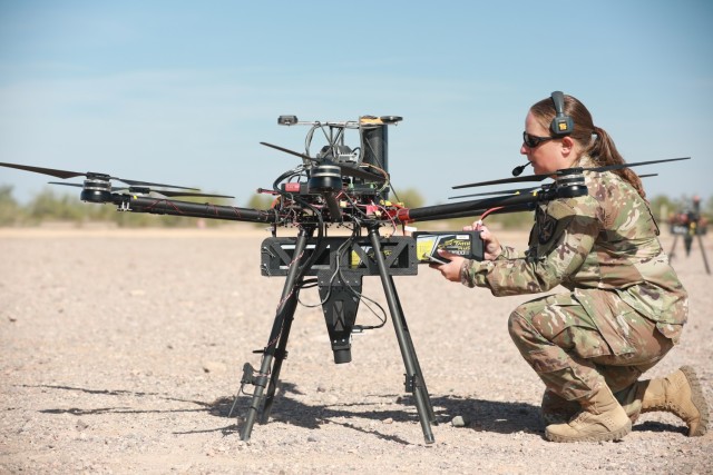 U.S. Army Staff Sgt. Elise Denning, assigned to Artificial Intelligence Integration Center, conducts maintenance on an unmanned aerial system in preparation for Project Convergence at Yuma Proving Ground, Arizona, on October 20, 2021. During PC21, Soldiers are experimenting with ways to use UAS to do autonomous target sensing, helping Soldiers see on the battlefield. (U.S. Army photo by Spc Destiny Jones)