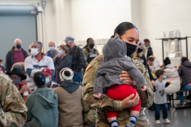 A Connecticut National Guard Soldier holds a child at a unit sendoff at the Army Aviation Support Facility in Windsor Locks, Conn. on Oct. 24, 2021. Her unit, the 142nd Medical Company, was mobilizing in support of Operation Atlantic Resolve and heading to Texas before deploying to Poland.