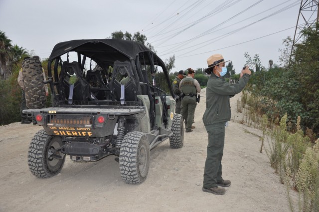 U.S. Army Corps of Engineers Los Angeles District Ranger Annel Monsalvo documents a debris field as LA County Sheriff deputies sweep the 120 acres of riverbank to be cleaned up. The Corps Los Angeles District cleared about 120 acres of riverbank,...