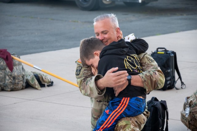 U.S. Army National Guard 1st Sgt. Dan Grenier hugs his son at the Army Aviation Support Facility in Windsor Locks, Conn. on Oct. 24, 2021. Grenier's unit, the 142nd Medical Company, was mobilizing in support of Operation Atlantic Resolve and heading to Texas before deploying to Poland.