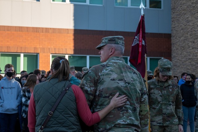 First Sgt. Dan Grenier and his wife stand in front of a formation of Soldiers from the 142nd Medical Company and their family members outside of the Army Aviation Support Facility in Windsor Locks, Conn. on Oct. 24, 2021. The unit was mobilizing in support of Operation Atlantic Resolve and heading to Texas before deploying to Poland.