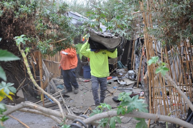 Workers remove trash from an abandoned homeless campsite, Sept. 27, 2021, near Whittier, California, as part of a two-week cleanup by the U.S. Army Corps of Engineers Los Angeles District. About 120 acres of creek and riverbank were cleaned,...