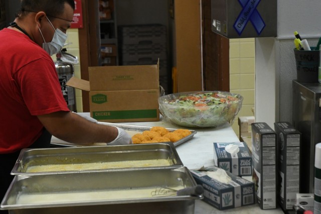 Lead dinner cook, Edgar Garcia prepares more than 100 pounds of chicken and 20 pounds of rice to make Chicken Cordon Bleu for the soldiers taking part in Project Convergence 2021.