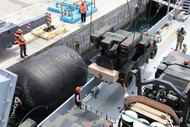 Soldiers of the 97th Transportation Company, 7th Sustainment Brigade, and civilian contract workers load an Avenger Air Defense System assigned to 1st Battalion, 174th Air Defense Artillery Regiment onto an Army Watercraft System in support of exercise  Forager 21 on July 28, 2021, Naval Station Guam. Exercise Forager 21 is a U.S. Army Pacific exercise designed to test and refine the Theater Army’s ability to flow landpower forces into the theater, execute command and control of those forces, and effectively employ them in support of our allies, partners, and national security objectives in the region. (Photo by Army Spc. Olivia Lauer)
