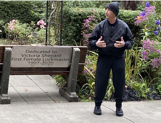 Photo of Allen Schwerer standing alongside the memorial bench