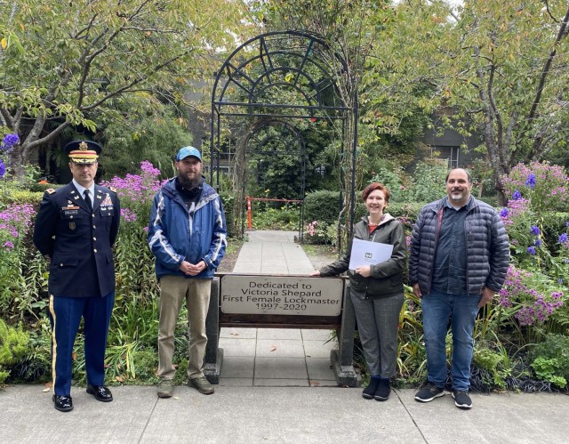 Photo of Colonel Bullock, Jen Shepard, her husband Eric and Jon Hofstra next to the memorial bench.