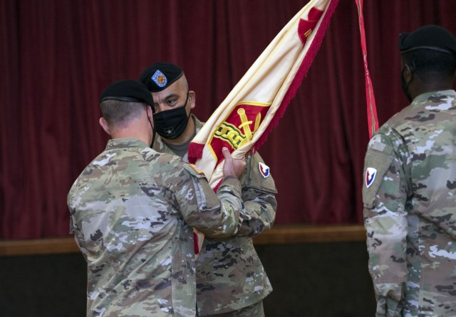 Garrison Command Sgt. Maj. R. Cesar Duran takes the unit colors from Garrison Commander Col. Ryan Hanson during a change of responsibility ceremony at the NCO Club Oct. 27. Duran assumed responsibility for the unit from Command Sgt. Maj. Algrish...