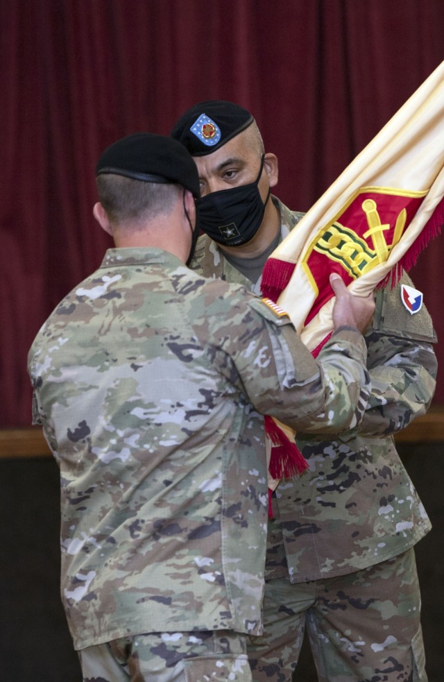 Garrison Command Sgt. Maj. R. Cesar Duran takes the unit colors from Garrison Commander Col. Ryan Hanson during a change of responsibility ceremony at the NCO Club Oct. 27. Duran assumed responsibility for the unit from Command Sgt. Maj. Algrish Williams during the ceremony.
