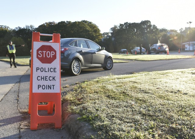 A Fort Leonard Wood Directorate of Emergency Services Police Officer instructs an on-post driver to pull in to a checkpoint Friday in the parking lot of the Lieber Heights Swimming Pool on Turner Street. The checkpoint was one of several conducted...