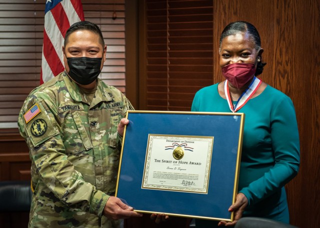 Col. Steven Yamashita, U.S. Army Military Police School assistant commandant, presents Donna Ferguson, USAMPS Behavioral Sciences Education and Training Division chief (right), with the Department of Defense Spirit of Hope Award Wednesday at the Maneuver Support Center of Excellence headquarters building. The award is presented annually on behalf of the Office of the Secretary of Defense to seven individuals or organizations that embody entertainer and military supporter Bob Hope’s values of duty, honor, courage, loyalty, commitment, integrity and selfless dedication. 