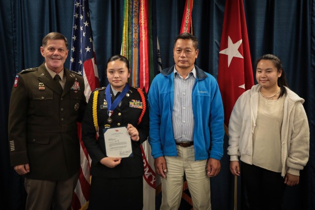 Army Materiel Command Deputy Commanding General Lt. Gen. Donnie Walker and Lee/New Century Technology High School JROTC Cadet Lt. Col. Weixing Zhang with Weixing’s father Chaobin Zhang and sister Weilan Zhang during an Oct. 27 award presentation at AMC headquarters. For more photos, visit the AMC Flickr album at: istribution of photos: https://flic.kr/s/aHsmX2D7rK . 