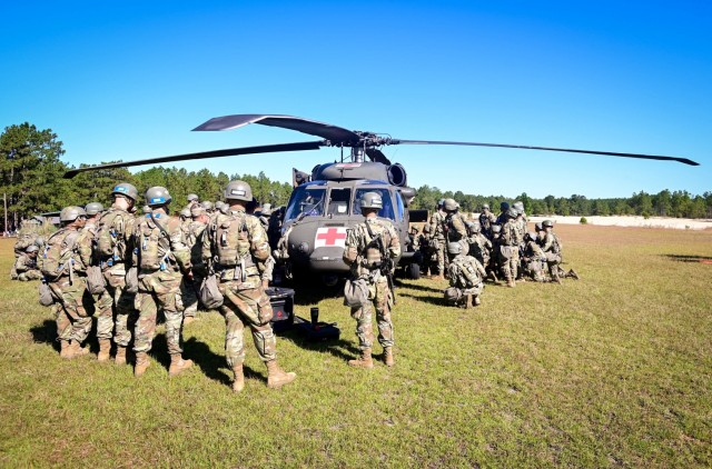 Trainees assigned to 1st Battalion, 34th Infantry Regiment, Fort Jackson, S.C., load a mock injured Soldier into a Black Hawk helicopter Oct. 18, 2021, as part of Tactical Combat Casualty Care, also known as TCCC. The trainee’s skills to provide care and transport casualties in the field are tested during the Forge. Two helicopters and flight crews assigned to the 2nd Battalion, 3rd General Support Aviation Battalion “Dust-off,” from Hunter Army Airfield located in Savannah, Ga., flew to the installation to help teach the trainees to load and unload a patient from the aircraft. Each team of trainees practiced their skills as the helicopters took off and returned to the landing zone marked by white smoke and orange flags staked into the ground to provide real-world experience during the training event.