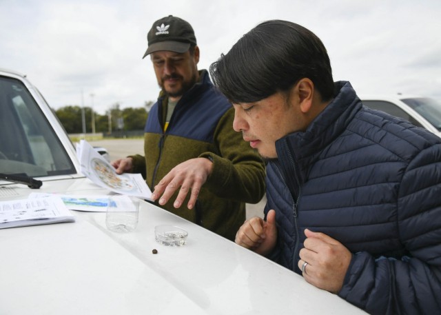 Antioch Middle School science teacher Thomas Yan looks closely at the water creators U.S. Army Corps of Engineers Nashville District biologist Travis Wiley has gathered to show examples of living indications of a healthy river ecosystem at the Drakes Creek Park in Hendersonville, Tennessee, Oct. 26, 2021. (USACE Photo by Misty Cunningham)