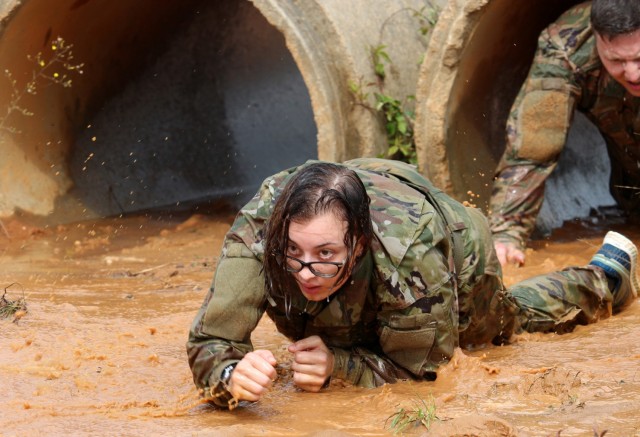 Competitors crawl through a flooded mud pit during the 1st Cyber Battalion "mungadai" 24-hour challenge, at Fort Gordon, Ga., Oct. 22, 2021. (Photo by Bill Roche)