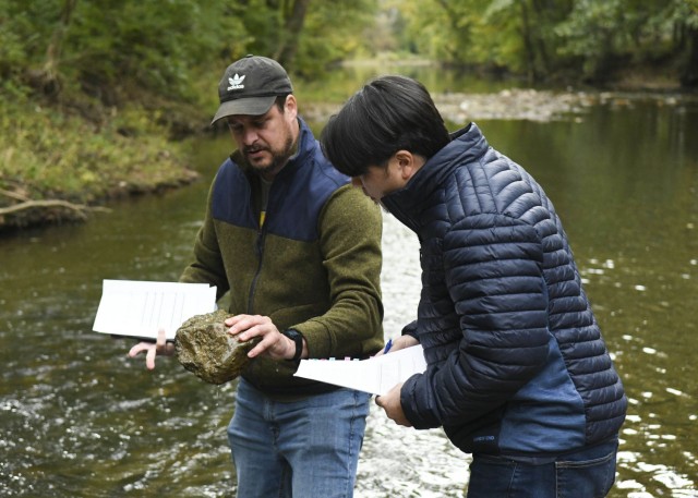 Antioch Middle School science teacher Thomas Yan looks on as USACE Biologist Travis Wiley points out all the aquatic invertebrates living on the surface of a steam rock, giving clear indication on the lake's healthy water quality at Drakes Creek Park in Hendersonville, Tennessee, Oct. 26, 2021. (USACE Photo by Misty Cunningham)