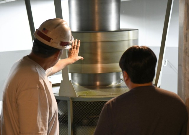 Old Hickory Senior Mechanic Greg Forte shows Antioch Middle School science teacher Thomas Yan where the original thruster bearings from 1956 are located on one of the underground hydropower generators at the Old Hickory Hydropower Plant in Hendersonville, Tennessee, Oct. 26, 2021. (USACE Photo by Misty Cunningham)