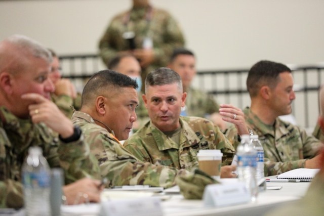 U.S. Army Lt. Gen. Antonio Aguto, commanding general of First Army (center) receives introductory briefing from Col. Matthew Hil (right)l, commander of the 11th Expeditionary Combat Aviation Brigade, U.S. Army Reserve, in a training facility in North Fort Hood, TX on October 26, 2021. 