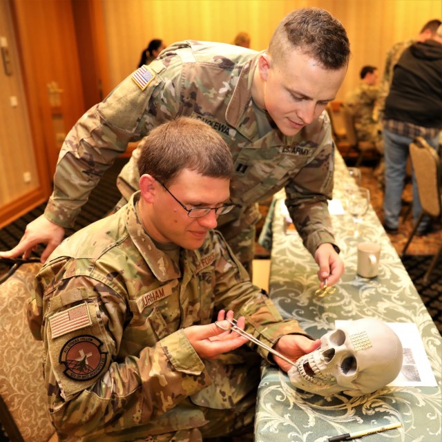 Two military dentists practice their dental skills on a training aid at the 63rd Annual Garmisch Dental Excellence Symposium held Oct. 25-29 2021.