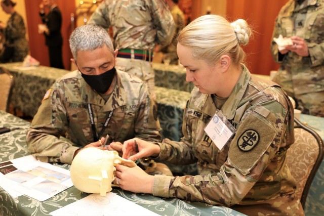 Col. (Dr.) Manuel Pozo-Alonso, commander of Dental Health Command Europe, assists an Army dentist with hands-on training during the 63rd Garmisch Dental Excellence Symposium held 25-29 Oct. 2021.