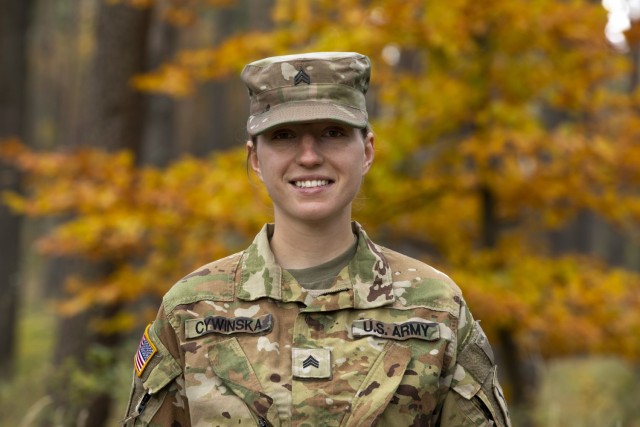 U.S. Army Sgt. Monika Cywinska, an AH-64 helicopter repairer with 1st Attack Reconnaissance Battalion, 1st Aviation Regiment, 1st Combat Aviation Brigade, 1st Infantry Division, who was born in Poland, poses for a photograph at Drawsko Pomorskie Training Area, Poland, Oct. 24, 2021. The 1ID is deployed to Europe as a rotational force in support of Atlantic Resolve, which provides ready and postured, combat-credible forces through multinational training and security cooperation activities. 